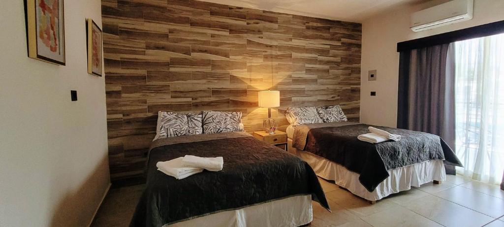 2 camas en una habitación con una pared de piedra en Doña Adelina House en Ciudad Valles
