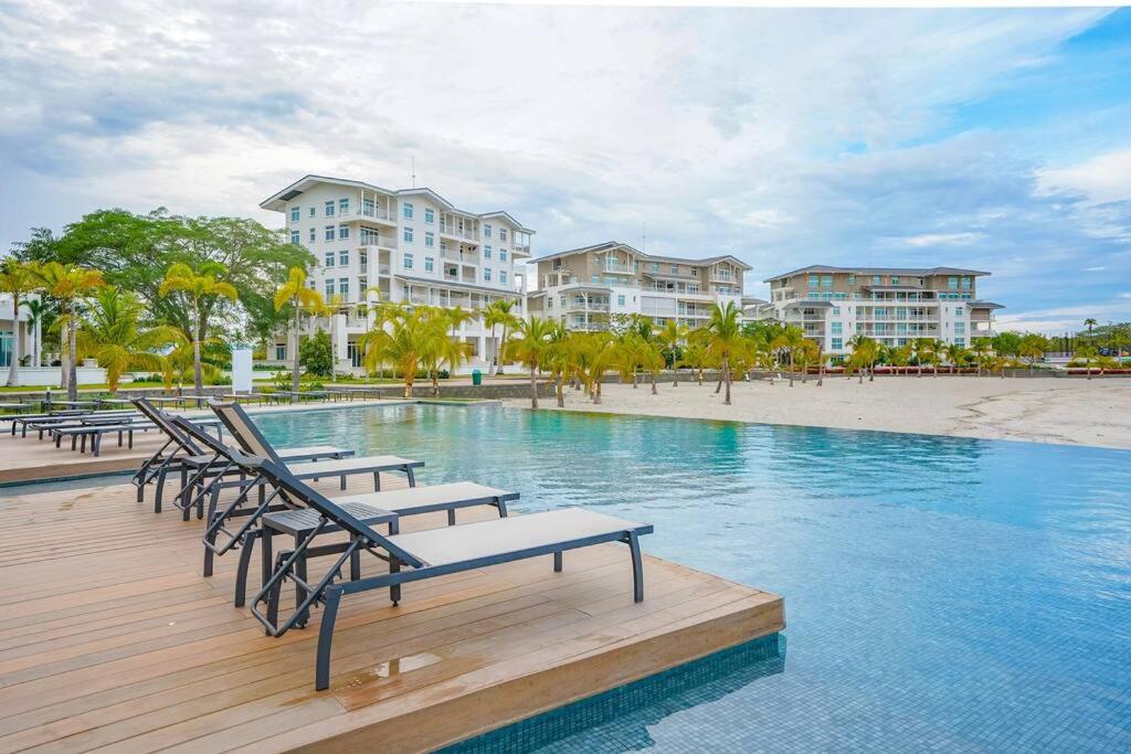 a pool with lounge chairs and some buildings at Modern - Marina View Balcony - Exquisite Pool - Sleeps 6 in Boca de Río Hato