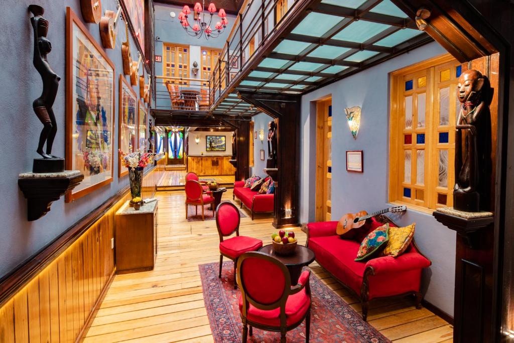 a living room with red couches and chairs at Hotel Parque México Suites at Condesa in Mexico City