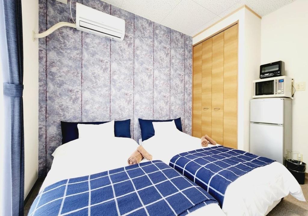 a bedroom with two beds with blue and white at Dia Palace Otemon 203 - Vacation STAY 12489v in Kanazawa