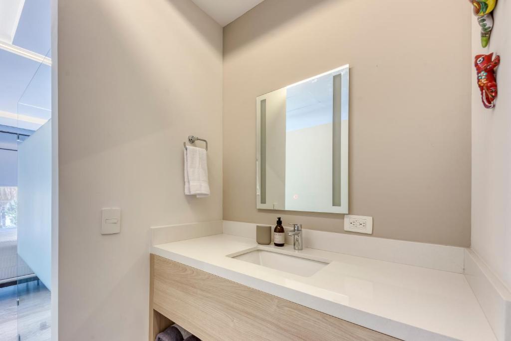 a white bathroom with a sink and a mirror at Lumina at Cardinal San José del Cabo in San José del Cabo