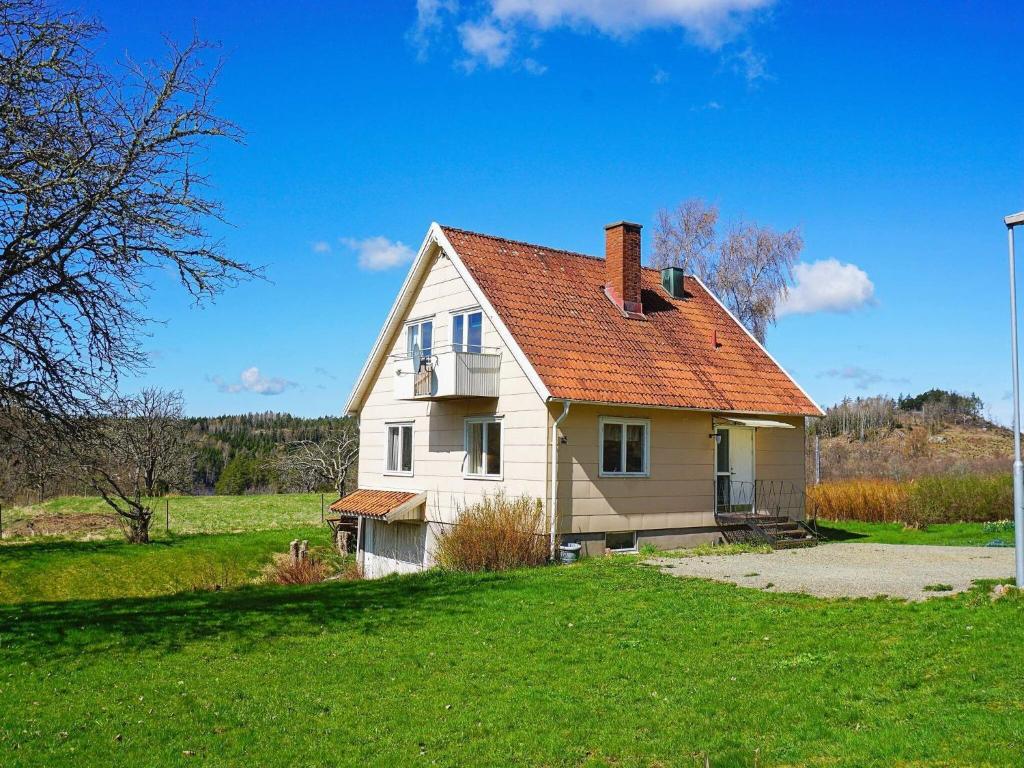 a white house with a red roof on a green field at Holiday home HÄLLEVADSHOLM II in Hällevadsholm