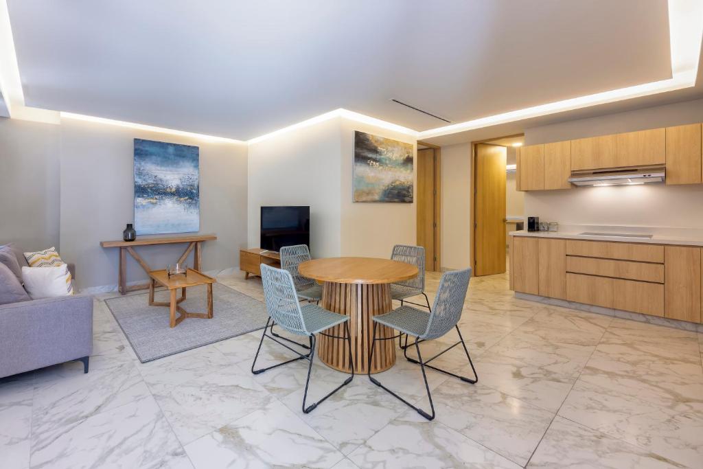 a living room with a table and chairs and a kitchen at Lumina at Cardinal San José del Cabo in San José del Cabo