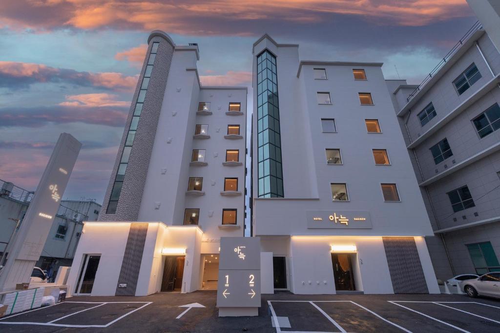 a large white building with two tall buildings at The Hyoosik Aank Hotel Daejeon Yooseong Hot Spring 1st Branch in Daejeon