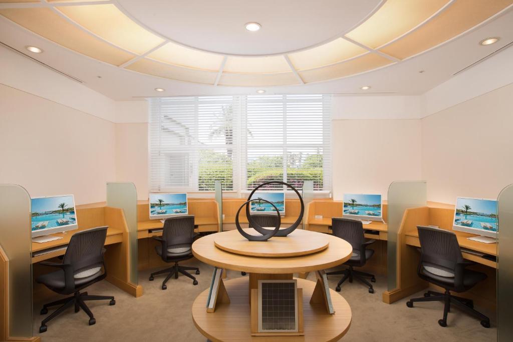 a room with desks and chairs and a table with a laptop on it at The Shilla Jeju in Seogwipo