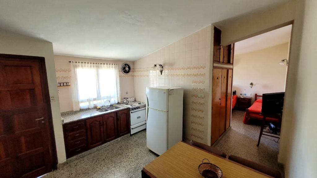 uma cozinha com um frigorífico branco e uma janela em Departamento em Termas de Río Hondo