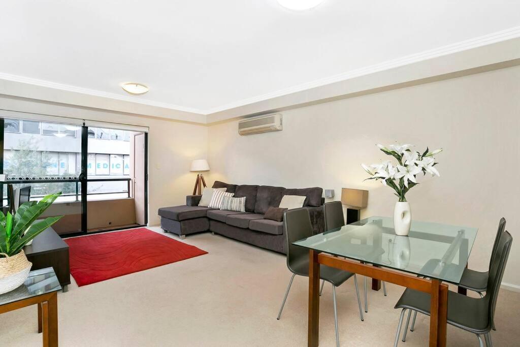 a living room with a glass table and a couch at BAR09- 1 bedroom unit In Heart of Cremorne in Sydney