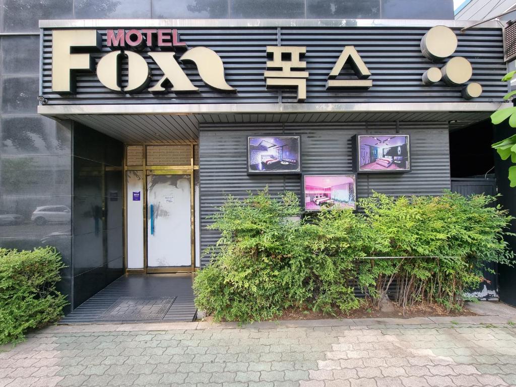 un frente de tienda con un cartel que lee World forza en Fox Motel en Daegu