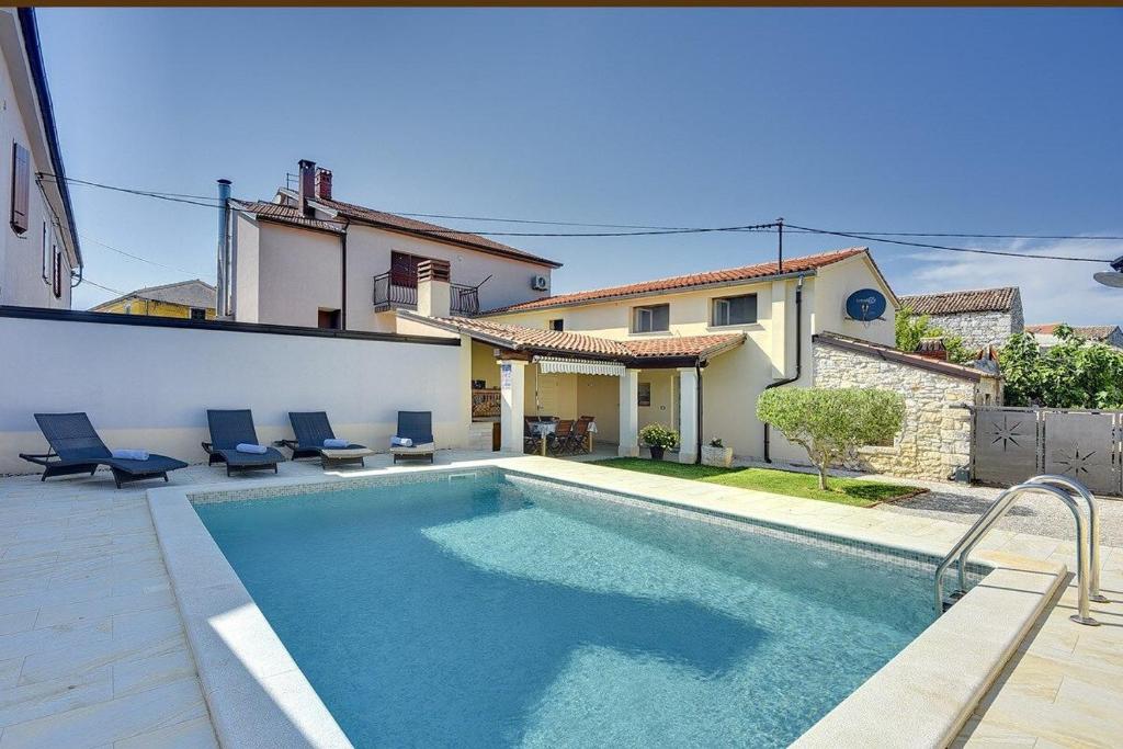 a swimming pool in front of a house at Villa Villetta Valtura in Ližnjan