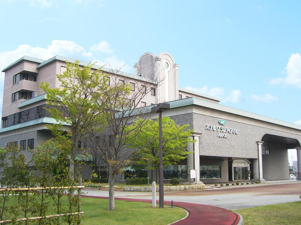 a building with a tree in front of it at Route Inn Grantia Komatsu Airport in Komatsu