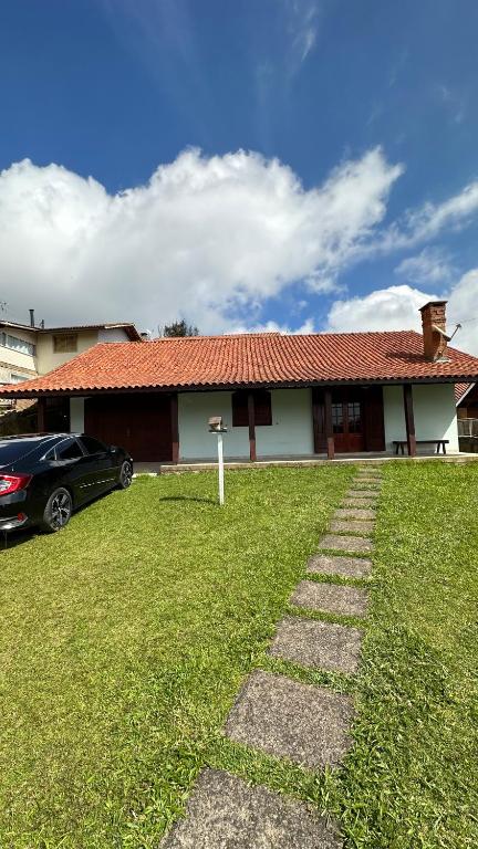 una casa con una macchina parcheggiata di fronte di Casa Ipê a Monte Verde