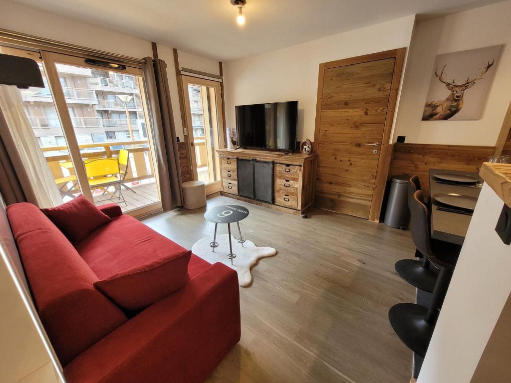 salon z czerwoną kanapą i telewizorem w obiekcie Appartement Les Gets, 2 pièces, 4 personnes - FR-1-598-142 w mieście Les Gets