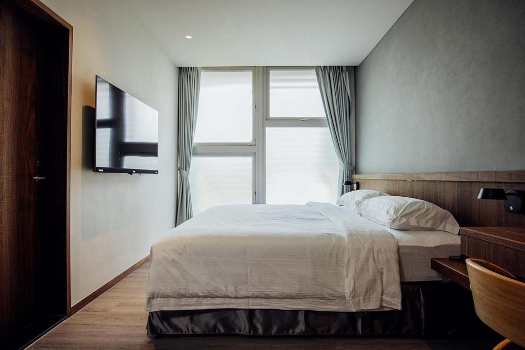 Postel nebo postele na pokoji v ubytování Hotel BEGINS 倉箱蜜境文旅