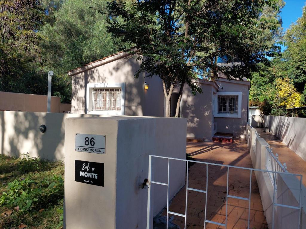 una pequeña casa con una valla y una puerta en Sol y Monte en Capilla del Monte