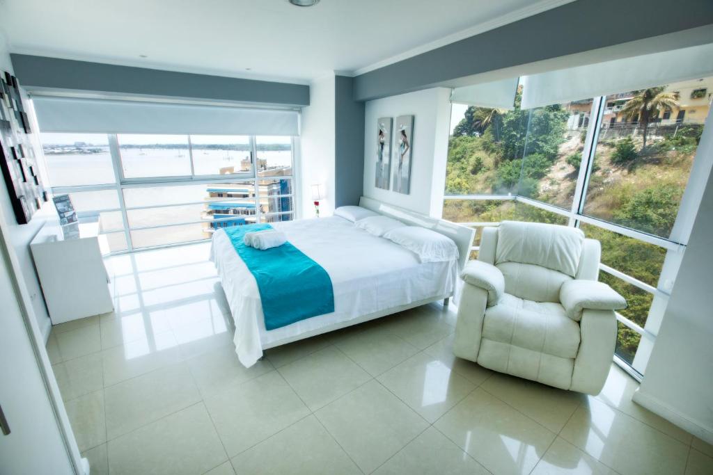 una camera con un letto e una sedia e una finestra di Suite 1107 Hermosa vista al rió Guayas con Jacuzzi a Guayaquil