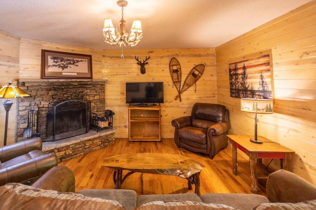 Pet friendly Luxury Cabin near Helen with fire pit في كليفلاند: غرفة معيشة مع أريكة ومدفأة