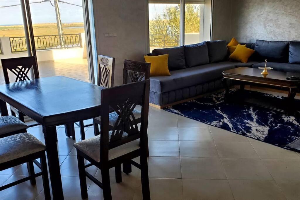 a living room with a couch and a table and chairs at New apartment with water view in El Jadida