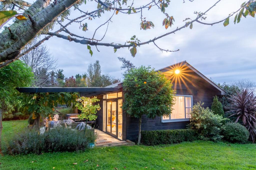 una piccola casa con una luce che splende su di essa di The Chefs Cottage a Waikanae