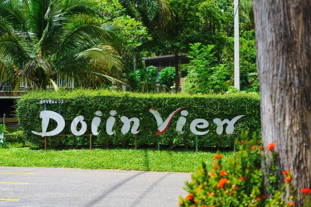 a sign that says donut sign in front of a hedge at Doi Inthanon View Resort in Chom Thong