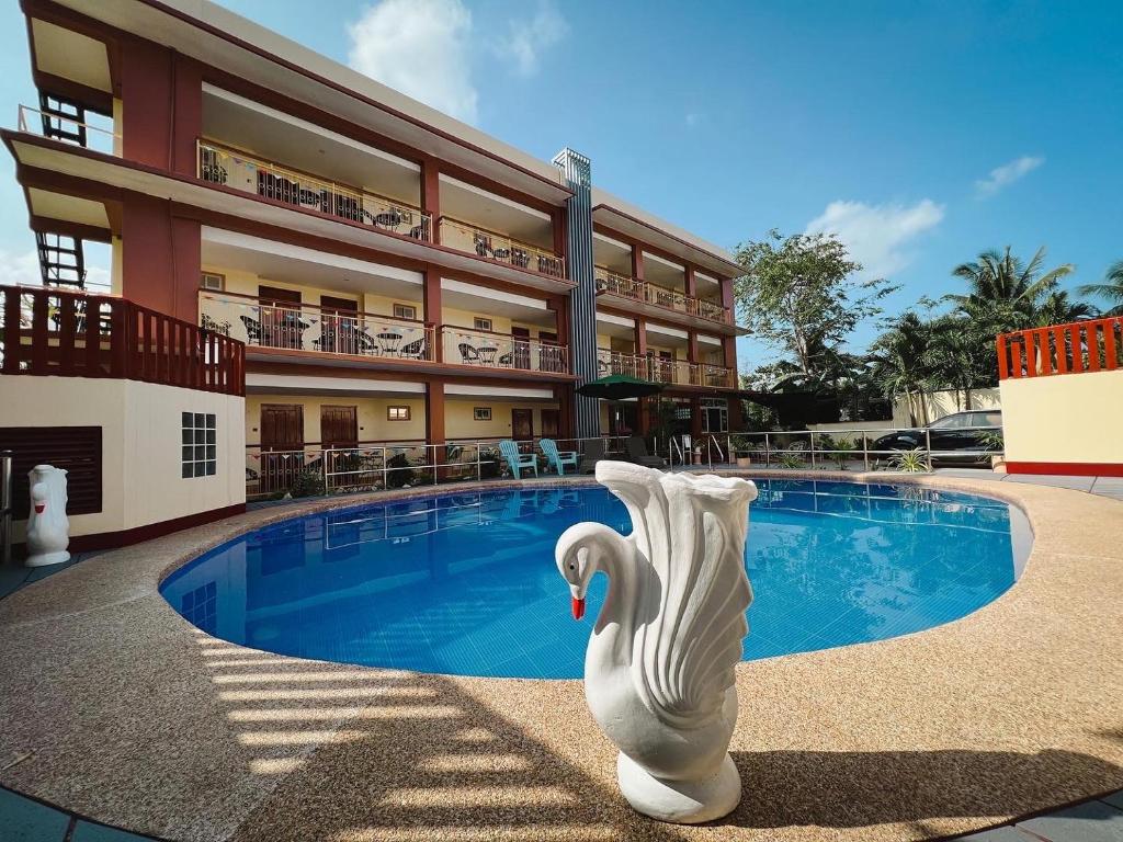 a building with a swimming pool in front of a building at Rufana Suites in Moalboal