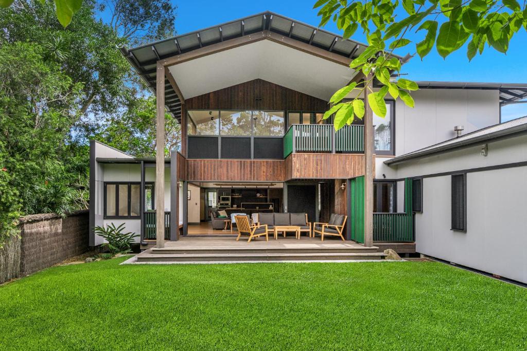 a modern house with a dining area in a yard at Belongil Laneway in Byron Bay