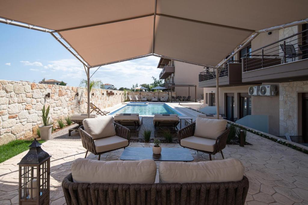 a patio with a couch and chairs and a pool at VagAthan - Lux Holidays in Afitos