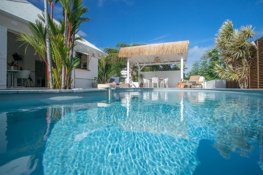 a swimming pool with blue water in a house at PARADISE BAY in Le Robert