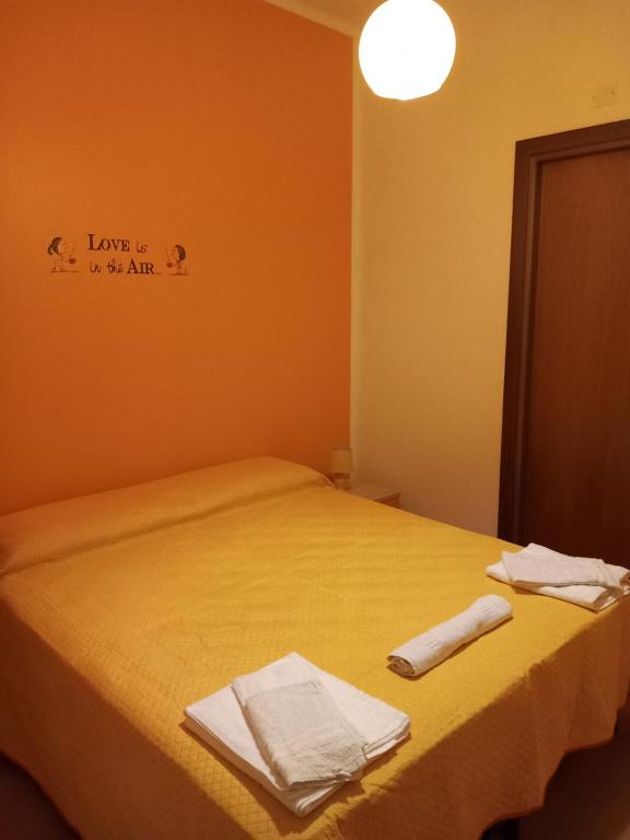 a bedroom with a yellow bed with towels on it at Dolce dormire in Fulgatore
