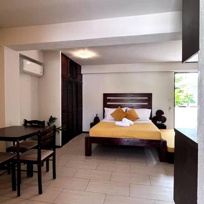 LogonにあるAngelina Villas_R1_Arte Casa_Malapascuaのベッドルーム1室(ベッド1台、テーブル付)、ダイニングルームが備わります。