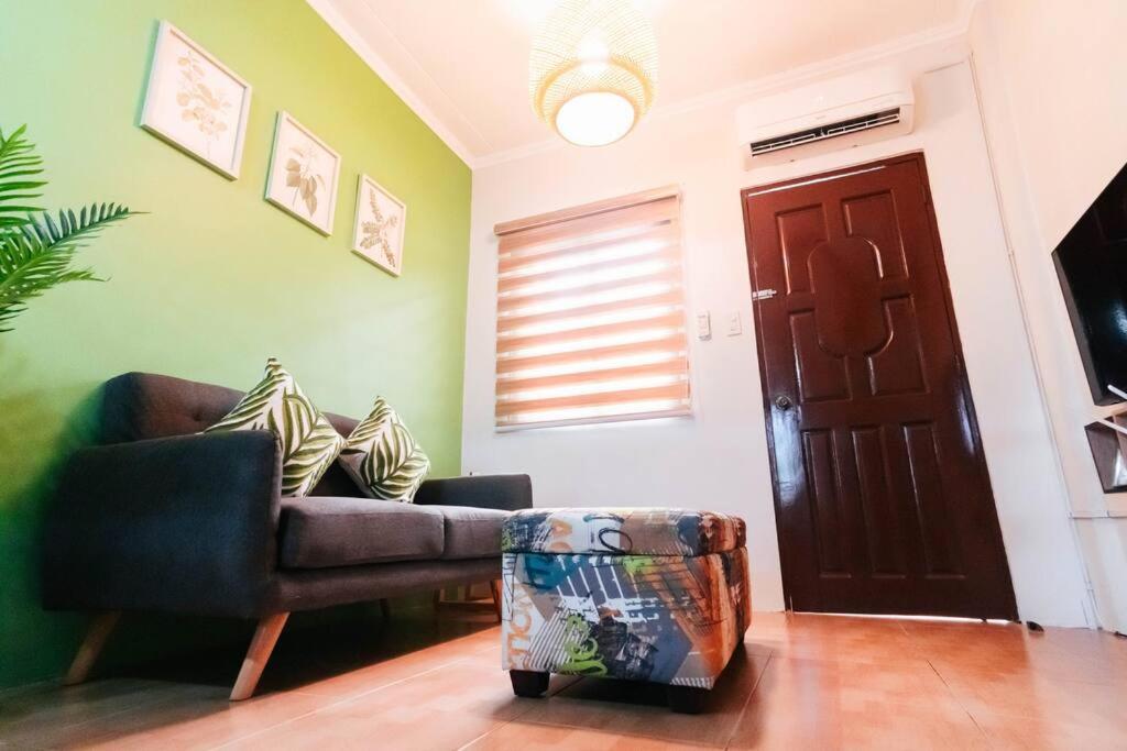 a living room with a couch and a door at Cozy BNB - Unit L in Batangas City