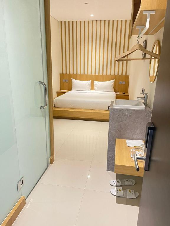 Een bed of bedden in een kamer bij The Risman Hotel At Jakarta Airport CBC