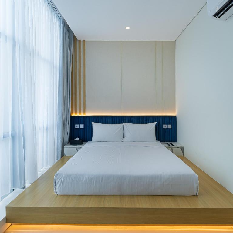 Een bed of bedden in een kamer bij The Risman Hotel At Jakarta Airport CBC