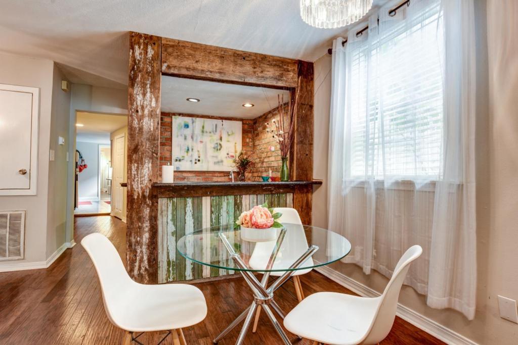 a dining room with a glass table and white chairs at Step into the French Quarter in New Orleans