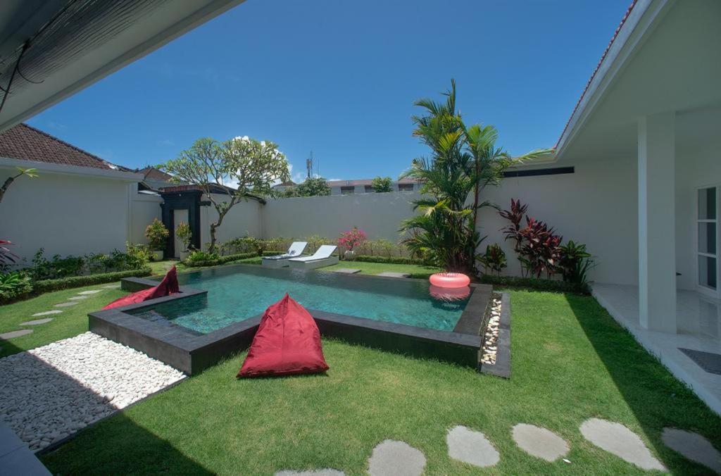a small backyard with a pool and grass at Modern 3 Bedrooms Villa Beach Walking Distance in Seminyak