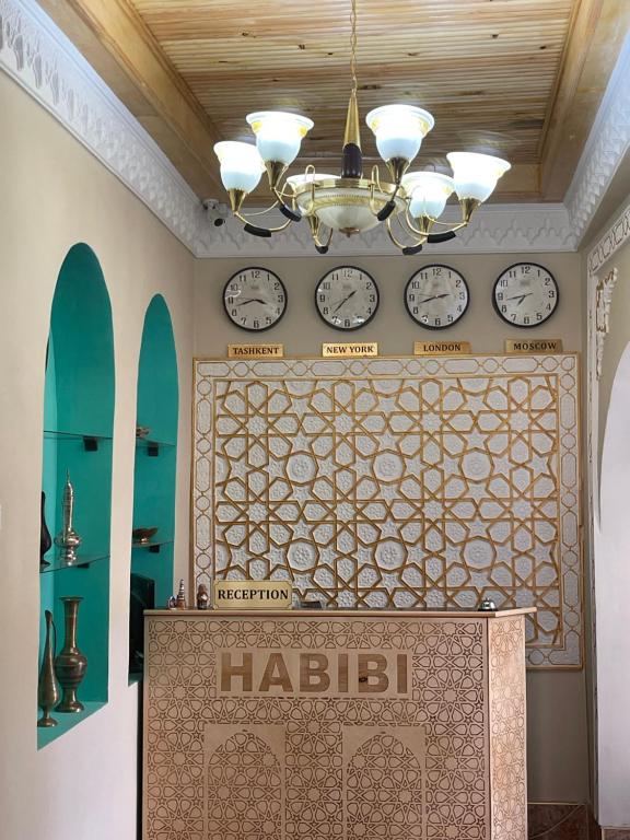 a room with clocks on the wall and a table at Habibi Bukhara in Bukhara