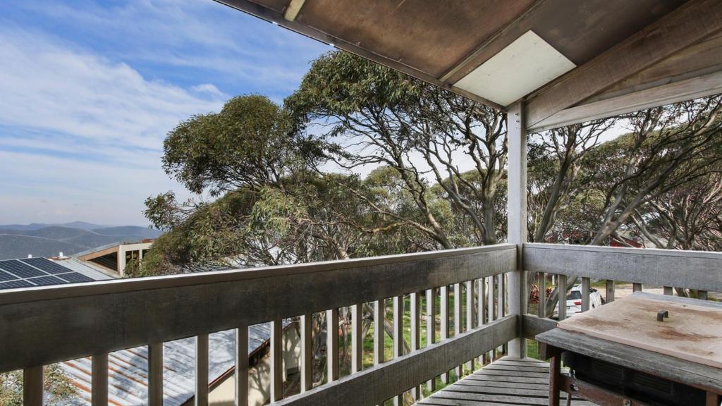 a balcony with a table and a view of the ocean at Shamrock 8 in Mount Hotham
