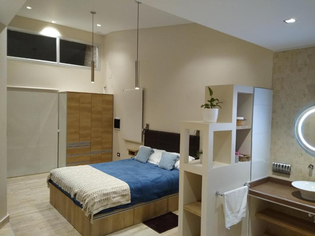 1 dormitorio con 1 cama y baño con lavamanos en De Alma Tinta - Petit Chalet en San Rafael