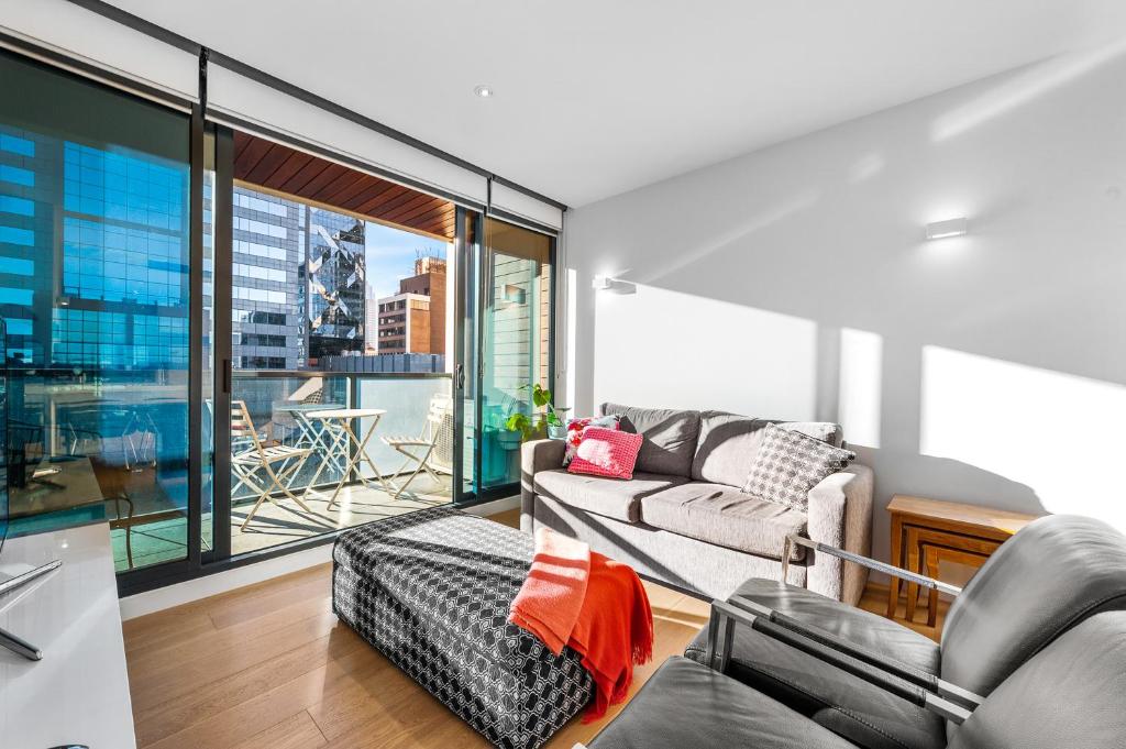 a living room with a couch and a large window at Luxe at Paris end Melbourne in Melbourne