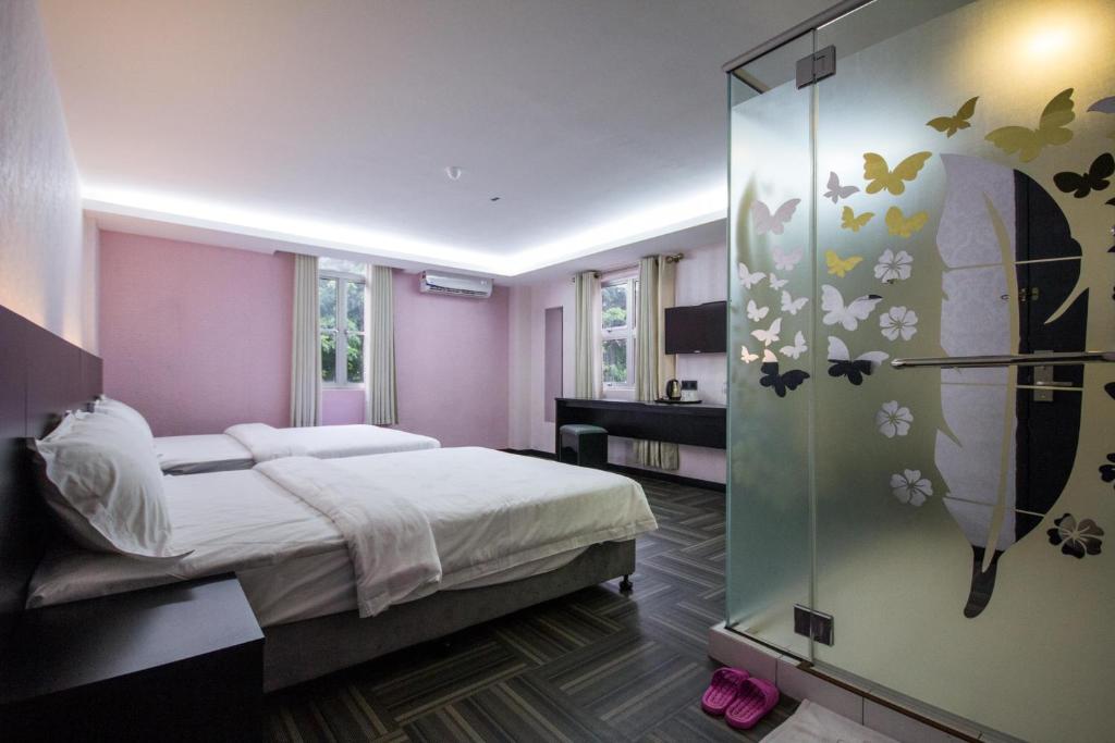 北赖S Hotel Seberang Jaya的带床和玻璃墙的卧室