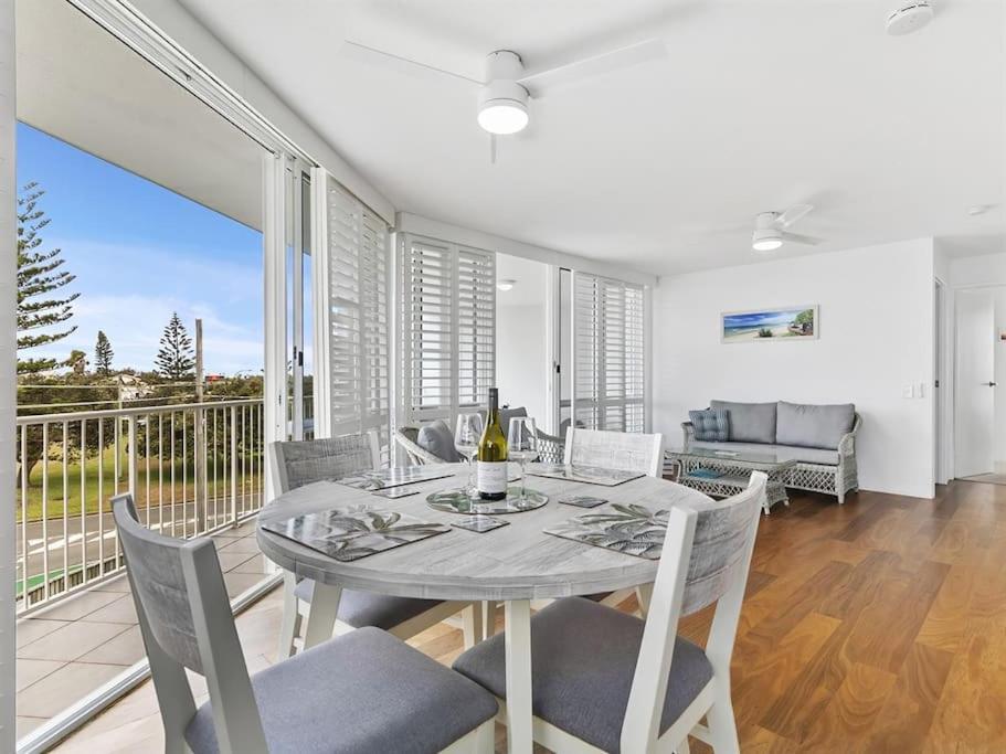 a dining room with a table and chairs and a balcony at Kawana Beachside Getaway 1 Bedroom Apartment in Buddina