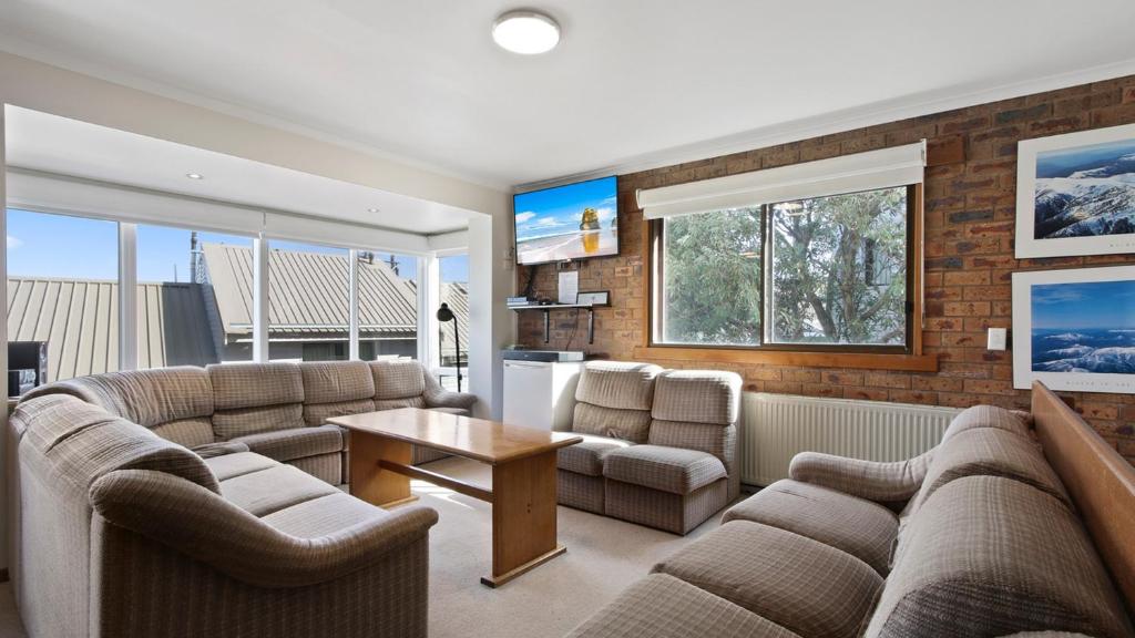 a living room with two couches and a table at Lawlers 17 in Mount Hotham