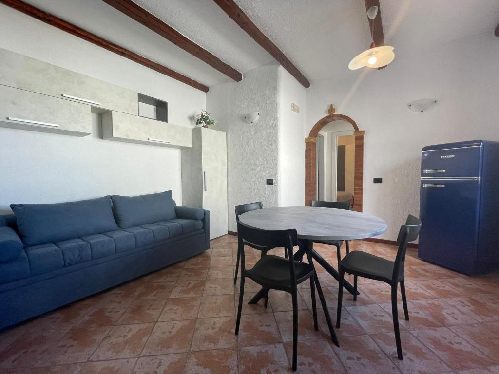 un soggiorno con divano blu e tavolo di Casa Riviera a San Vito lo Capo