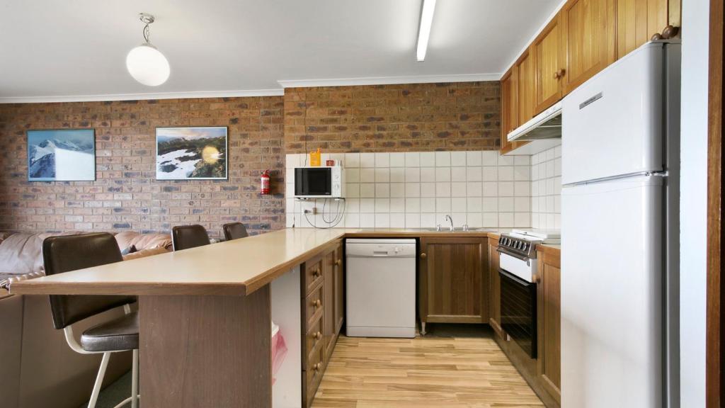 a kitchen with a white refrigerator and a counter at Lawlers 31 in Mount Hotham