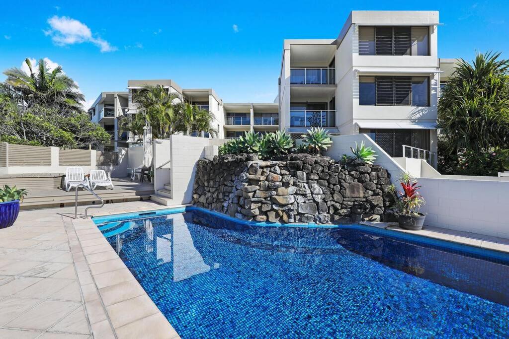 a swimming pool in front of a building at Beachside Views 2 Bedroom Apartment Mooloolaba in Mooloolaba