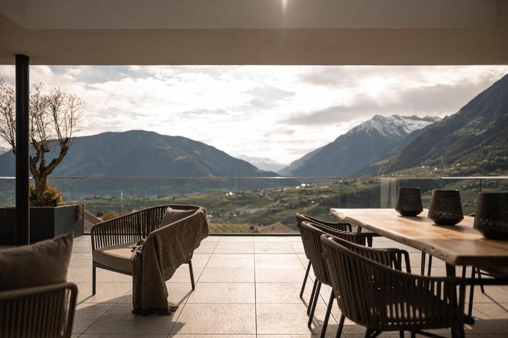 a table and chairs with a view of mountains at View House - Chalet Goyen in Schenna