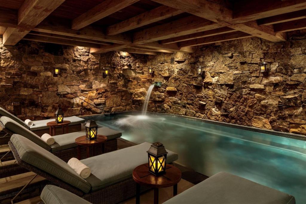 a pool in a room with a stone wall at Bachelor Gulch Ritz-carlton 1 Bedroom Mountain Residence With Ski In, Ski Out Access, Hot Tub, And Full Service Spa in Avon