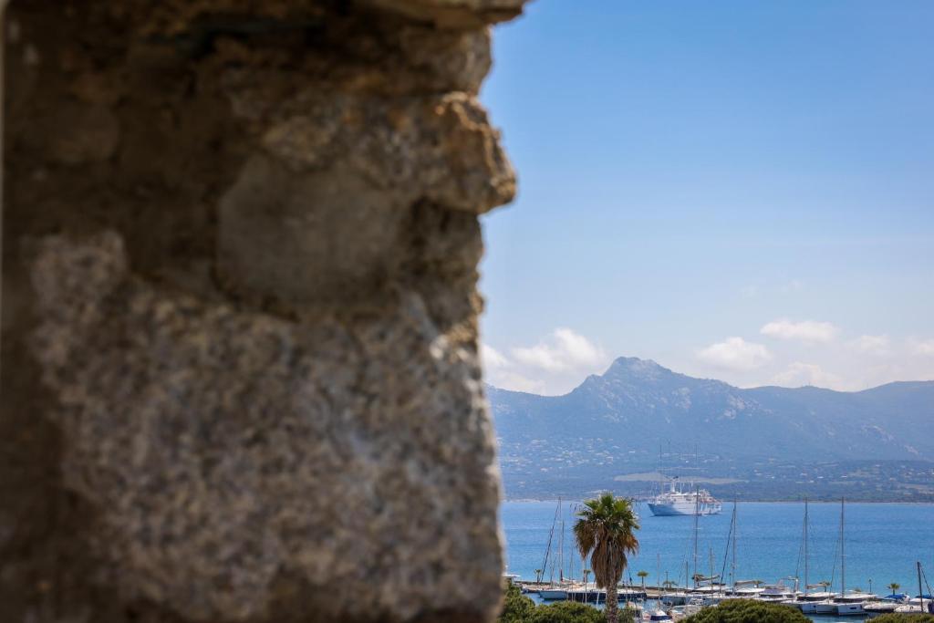 a view of the ocean and a cruise ship at Hôtel L'Abbaye in Calvi