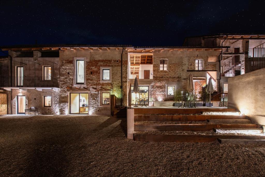 - un grand bâtiment en pierre avec des escaliers devant lui la nuit dans l'établissement La Casa nel Relais, à Novello
