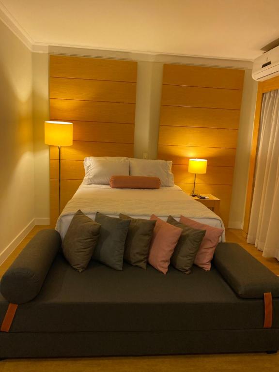 1 dormitorio con 1 cama con almohadas en un sofá en Flat Congonhas, en São Paulo