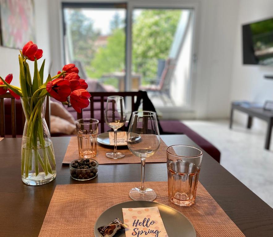 een tafel met wijnglazen en een bord eten bij Lilie Appartement in Hévíz mit Tiefgarage, new and modern in Hévíz